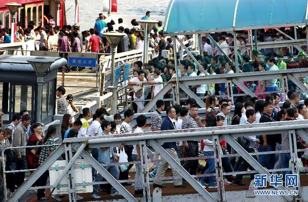 10月1日，游客在上海外滩排队乘坐观光游轮。当日是国庆长假第一天，全国各地旅游景点游人如织。 新华社记者 丁汀 摄