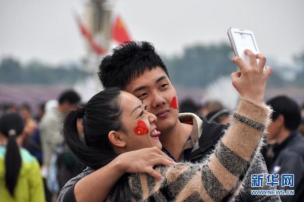 10月1日，一对年轻人在天安门广场自拍。