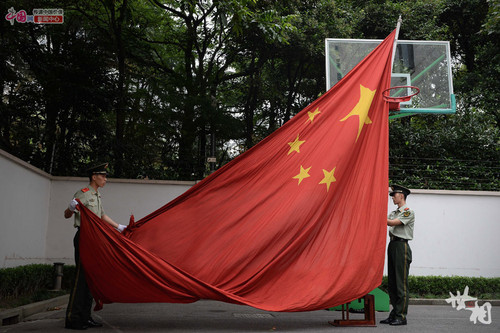 　升旗手林孝诚（左）和护旗手在训练收国旗。