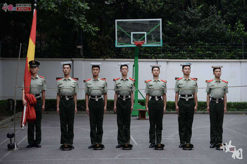 　一名老战士在带新战士训练站姿。