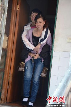 梅慧平背着大儿子许翼出门　马芙蓉　摄