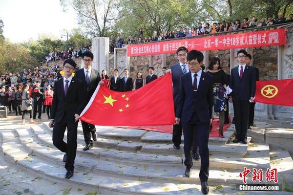 10月16日，学生们举起老师们赠送的国旗。