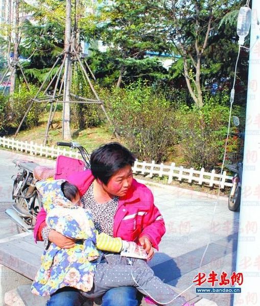 环卫工人刘彩娜陪女儿在路边打吊瓶