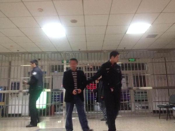 图为房东（中）被警察带回警局。