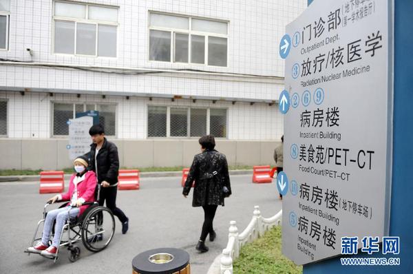 11月5日，于海宁推着范会香去进行放射治疗。 新华社记者 李博 摄