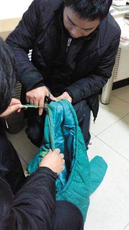 昨日京京的父亲剪掉孩子外套的拉链，按照习俗，孩子走的时候不能穿带拉链的衣服。