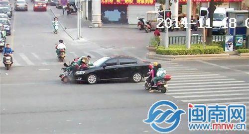 女子骑超标车载儿上学闯红灯 母子被小车撞飞