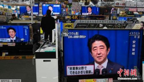 资料图：日本民众在电视机前观被劫持绑架日本人质事件播报