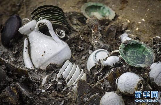 “南海一号”右侧中部船舱位置散落着一摞摞福建德化窑白瓷器和福建磁灶窑绿釉器。