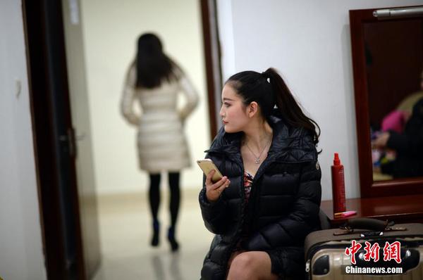 　　换装后，举牌女郎在化装室休息。中新社发 稻草 摄 图片来源：CNSPHOTO