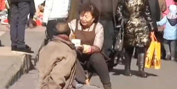 大妈蹲地给乞讨男子喂面4
