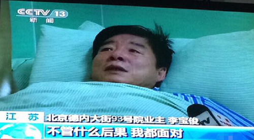 挖坑人大代表躺病床上受访，流泪称愿受惩罚。视频截图