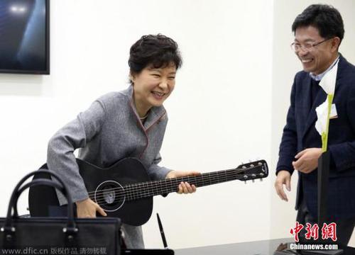 当地时间2014年11月24日，韩国全罗北道全州市，总统朴槿惠出席“创造经济革新中心”揭牌仪式，并视察该中心，朴槿惠在视察中试弹用碳纤维材料制作的吉他多才多艺。图片来源：东方IC 版权作品 请勿转载