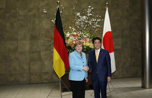 3月9日，在日本东京首相官邸，日本首相安倍晋三（右）欢迎到访的德国总理默克尔。新华社发