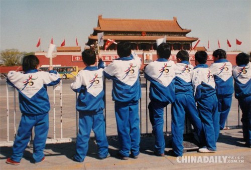 2001年春，北京天安门广场，几位身穿印有奥运五环图案校服的小学生举目远望，期盼北京奥运早日申办成功。（2001年7月使用胶片拍摄，2008年12月14日数码翻拍）