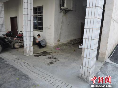 图为该男子蹲在墙角处专心上网。　刘洋　摄