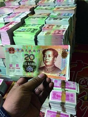 在印刷厂车间内，仿制市面流通的第五版人民币的冥币成堆摆放