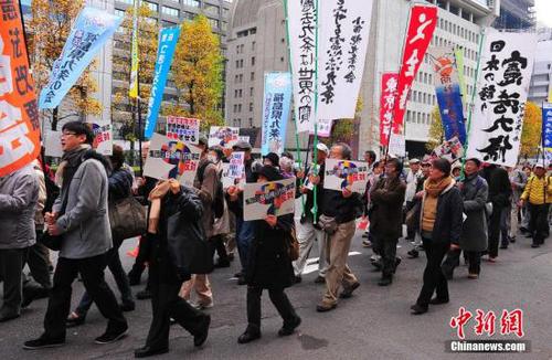 资料图：来自日本各地的数千名市民组织“守护宪法第九条之会”人士，在东京市中心的日比谷公园内举行大型集会，并在之后沿银座、有乐町等繁华街区游行，呼吁守护和平宪法，反对解禁集体自卫权。中新社发 王健 摄