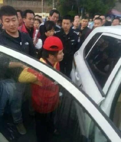 女志愿者被民警带上警车，受伤女子则被送医救治。