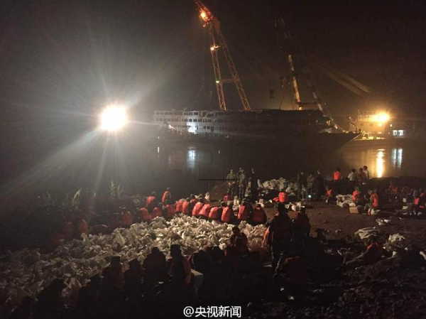 6月9日晚，打捞出水的“东方之星”发生一定程度倾斜，船体向左侧倾斜80厘米。武警官兵现场装沙袋配重调平，将沙袋运上东方之星右侧甲板放置，调平后将等待拖行至安全水域。据了解倾斜原因或与减载、水流等有关。央视记者刘峰 张宗尧 欧阳干湘 图片来源：央视新闻官方微博1