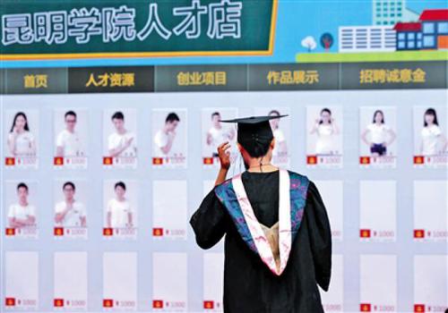 昨日，昆明学院一毕业生在人才店展板前驻足。当日，该校淘宝“昆明学院人才店”正式成立，65位毕业生亮相。新华社发