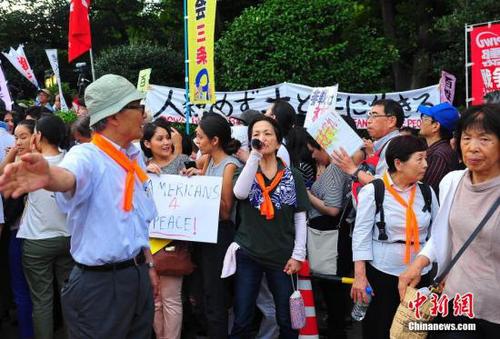 7月15日，安倍政权强推以解禁集体自卫权为核心的安保法案在众议院特别委员会表决过关，引发日本民意强烈反弹。当天上午起在国会周边出现的自发抗议活动，到晚间达到高峰：数万市民围聚到国会周边抗议示威，表达内心愤怒和担忧。王健 摄