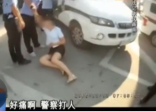 她随即坐在地上大叫“警察打人”。