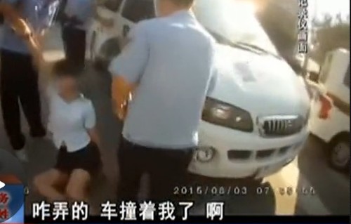 在拉扯中，女子撞到警车上。