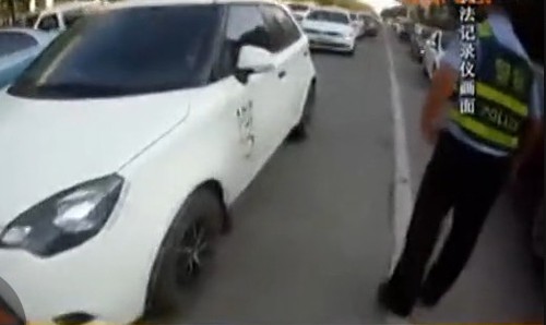 　由于路口被堵，民警只好指挥车辆从旁边绕行。