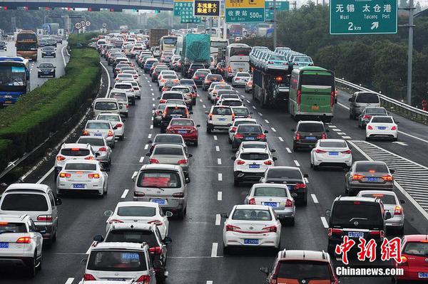 10月1日，江苏苏州，国庆长假高速公路免费通行第一天，沿江高速江苏省太仓主线收费站附近出现数百米的车流长龙，从上海方向驶出的大量车辆缓慢通行经过沿江高速江苏太仓段。计海新 摄 图片来源 CFP视觉中国