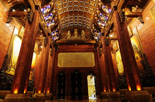 由门厅打开的那扇侧门，即可进入气势恢弘的梵宫内部。这儿是梵宫的廊厅，廊厅是由门厅进入圣坛的交通厅，整个廊厅为拱顶结构，高18米，长度近80米，中部被塔厅分为两段，全部采用金丝楠木雕刻而成。