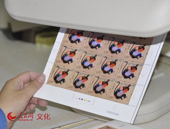 每一枚邮票中间蓝色的数字就是各自的专属“身份证号”;版面右下角黑色的数字则是此版邮票的编号。(人民网 王鹤瑾 摄)