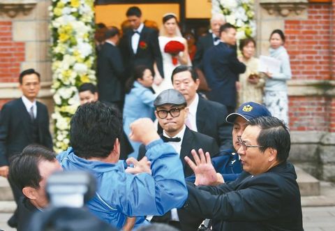 　李登辉孙女李坤仪（后排中）结婚，一名蓝衣男子突然丢纸闹场，李登辉和孙女面露惊恐。来源：台湾《联合报》