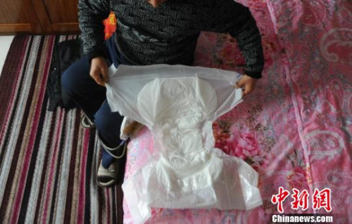 因为尿管会漏，申建军（化名）需要时常带着大号成人纸尿裤。　胡健　摄