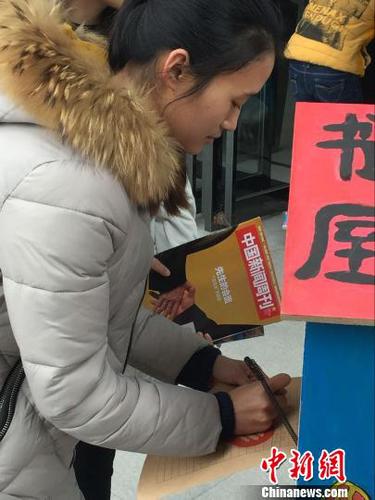 　两名大学生从“鸟巢书屋”取走书籍后自觉进行登记。　韩章云　摄