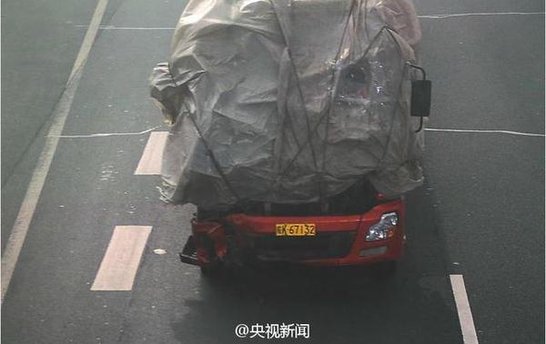 大货车车头蒙塑料布上高速 司机戴头盔驾驶(图)