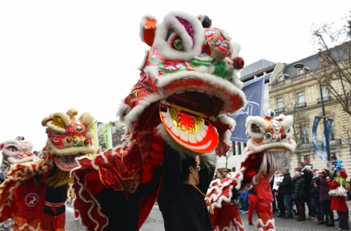 1月1日，在法国巴黎，来自巴黎华埠的谢卓贤金龙醒狮武术队在香榭丽舍大街表演舞狮。