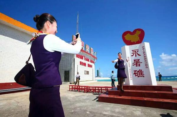 空姐在永暑礁上留影纪念。 新华社记者 查春明 摄 图片来源：中国军网