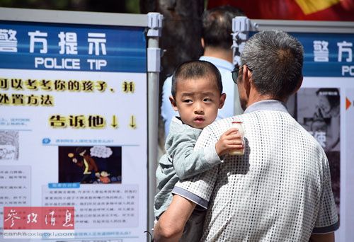 资料图：2015年6月1日，市民在观看长春市公安局发布的儿童安全常识。当日，吉林省长春市儿童公园举行“关爱儿童，反对拐卖”主题大型宣传活动。新华社记者