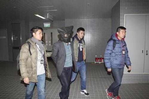 香港警方护送着史德运离开。