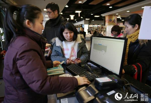 书店服务员帮助市民查阅该书是否可外借。