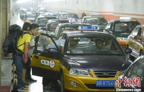 资料图：市民在北京西客站出租车候车点准备乘车。<a target='_blank' href='http://www.chinanews.com/'>中新社</a>发 侯宇 摄