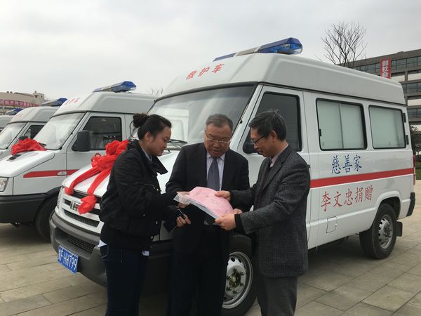 李文忠（中）与毕节市卫计委工作人员办理巡诊车交付使用的手续，右为毕节市卫计委主任邓韬。