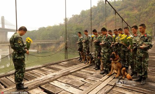 2016年3月29日，云南瑞丽，边防大队江桥警犬复训基地的官兵在警犬墓群前，带着警犬列队，悼念特殊的“警犬战友”，敬献花环。脱帽、默哀、敬礼，简单的仪式承载了官兵与警犬之间深厚的战友情谊。11年来，这个基地先后有12头警犬光荣地完成使命，葬在山头。
