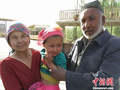 妈妈抱着被救的孩子与老人合影。　杨婷婷 摄