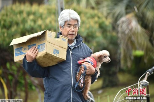 当地时间4月17日，一位老人抱着自己的爱犬领救灾物资。
