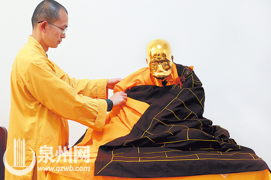 普照寺住持振宇法师为福厚长老金身穿上袈裟