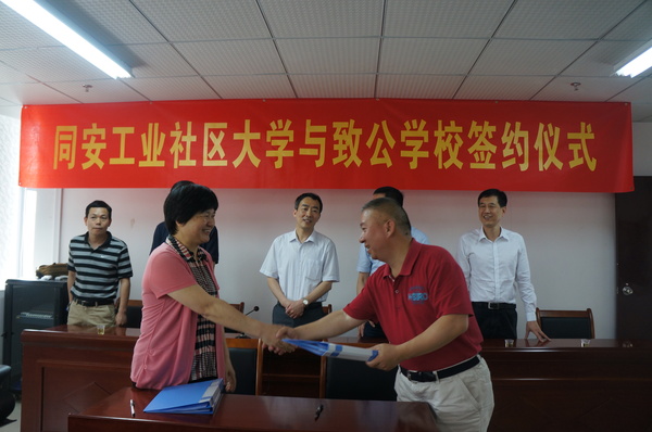 致公党同安总支主委李卫红（左一）与同安工业社区大学校长吴永红（右一）签订同安工业社区致公学校共建协议。2