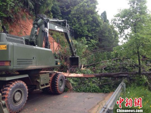 5月8日，官兵正在使用挖掘机清除道路障碍。　赖桥泉 摄