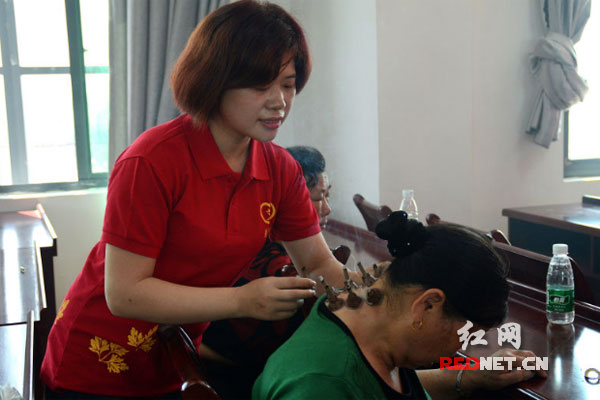 爱心团队的护师和志愿者为老年人进行艾灸理疗。